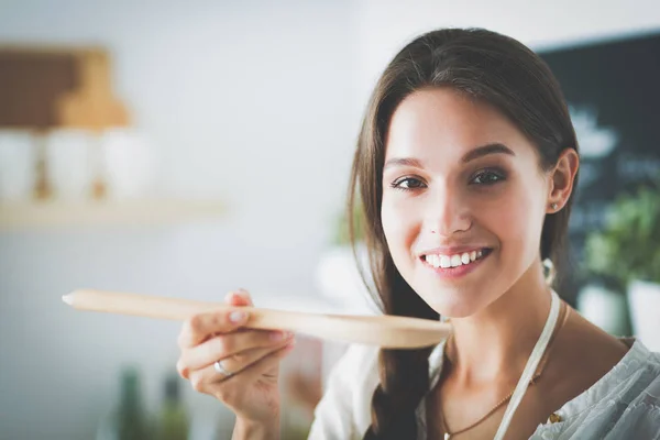 Mujer cocinera en cocina con cuchara de madera —  Fotos de Stock