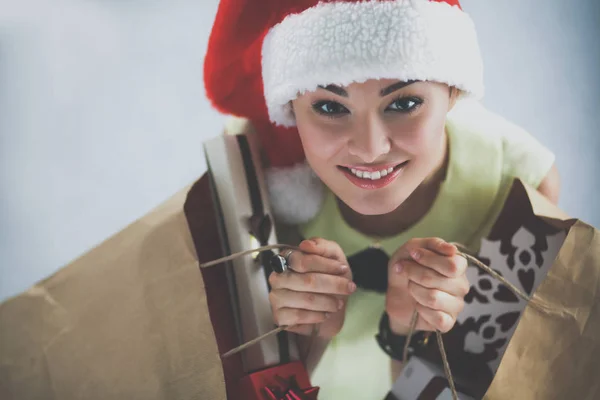 サンタ帽子ギフト ボックスとショッピング袋を持って幸せな女の子 — ストック写真