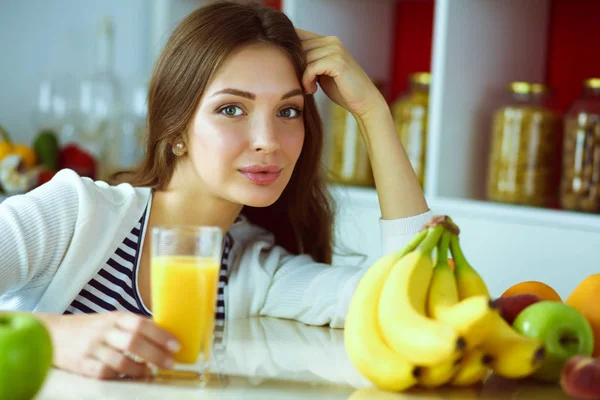 Wanita muda berdiri dekat meja di dapur — Stok Foto