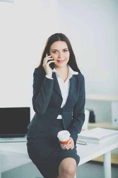 Uma bela mulher de sucesso falando ao telefone no escritório moderno — Fotografia de Stock