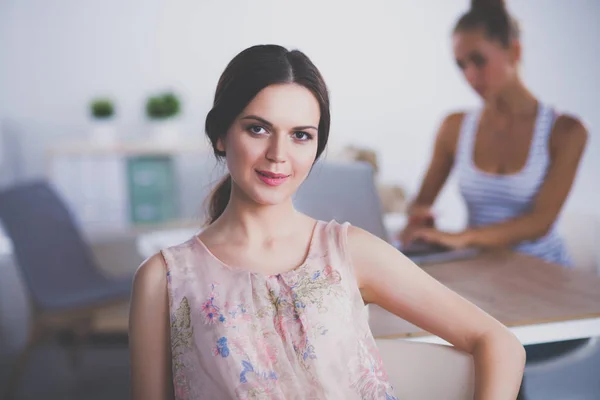 Atrakcyjna bizneswoman siedzi na biurku w biurze — Zdjęcie stockowe