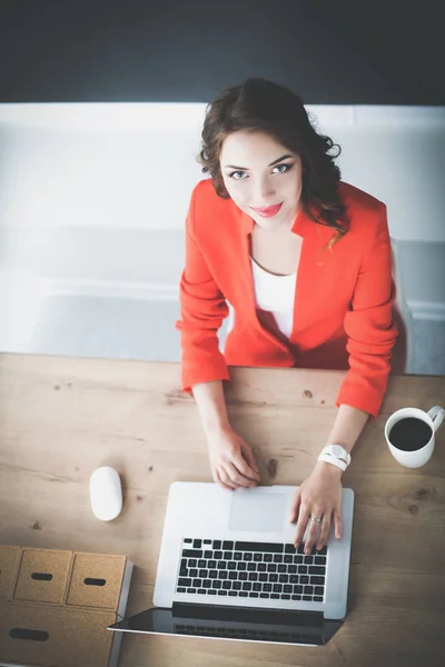 Attractive woman sitting at desk in office, working with laptop computer — Stock Photo, Image