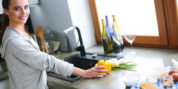 Güzel genç kadın mutfakta dururken salata sebze yıkama.