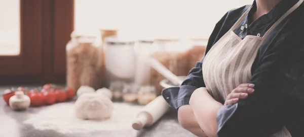 Hermosa mujer cocinando pastel en la cocina de pie cerca del escritorio —  Fotos de Stock