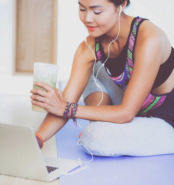 Deportiva mujer sonriente utilizando el ordenador portátil en habitación luminosa — Foto de Stock