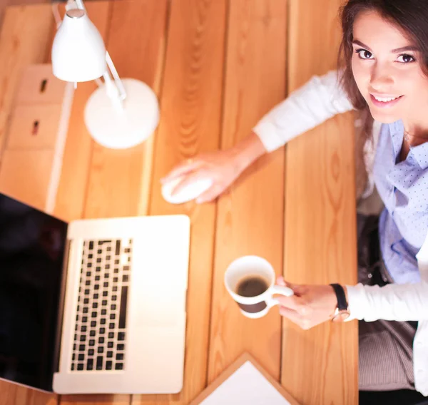 Portrait de jeune femme détendue assise à son bureau tenant une tasse de café — Photo