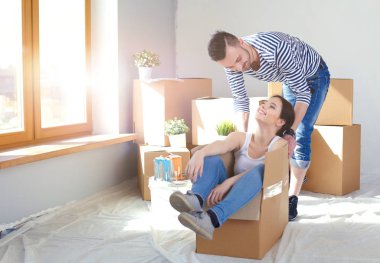 Açma veya kutu ambalaj ve yeni evine taşıdıktan mutlu genç bir çift. Genç Çift