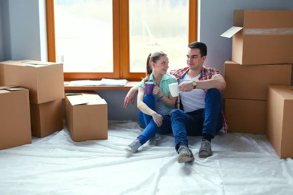 Par som flyttar i huset sitter på golvet. Par — Stockfoto