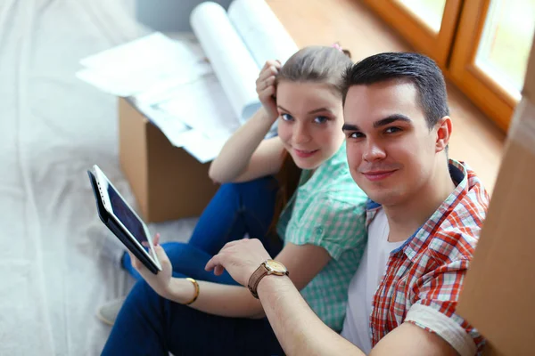 Pareja moviéndose en casa sentada en el suelo con ipad. Pareja. —  Fotos de Stock