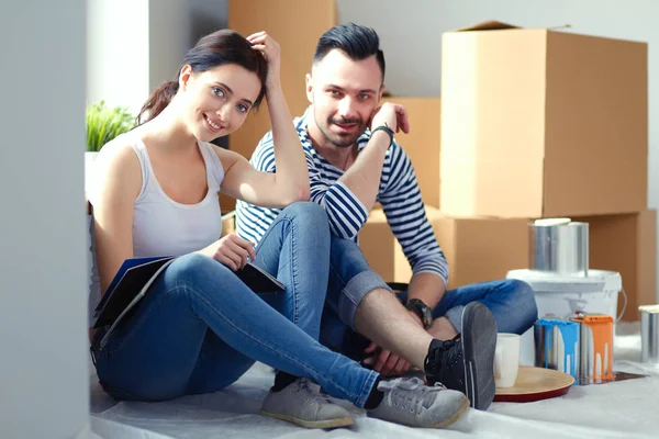 Couple moving in house sitting on the floor . Couple