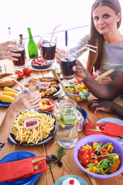 Vista superior do grupo de pessoas que jantam juntas enquanto estão sentadas à mesa de madeira. Comida na mesa. As pessoas comem fast food. — Fotografia de Stock