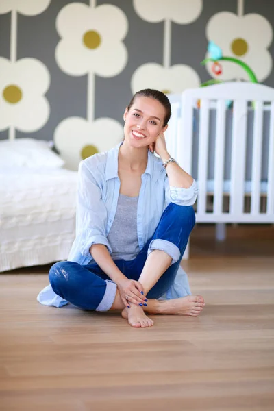 Jonge vrouw doet yoga thuis in de lotuspositie. Jonge vrouw doet yoga. — Stockfoto