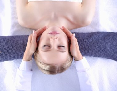 Masaj masasında uzanmış gözleri kapalı rahatlayan genç bir kadın. - Kadın. Spa salonu