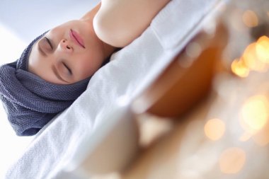 Masaj masasında uzanmış gözleri kapalı rahatlayan genç bir kadın. - Kadın. Spa salonu