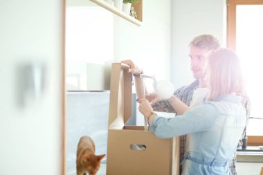 Genç bir çift yeni evde büyük karton kutu taşıyan. Ev taşıma. Genç Çift