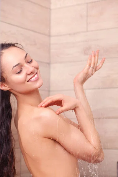 Jonge beautyful vrouw onder de douche in de badkamer. — Stockfoto