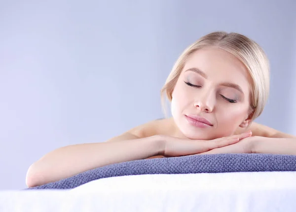 Femeia tânără întinsă pe o masă de masaj, relaxată cu ochii închiși. Femeie. Salon Spa — Fotografie, imagine de stoc