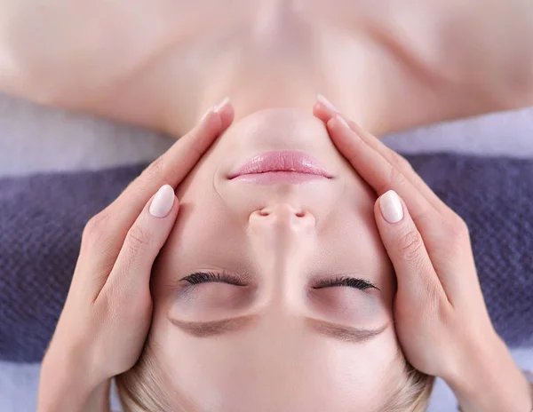 Mujer joven acostada en una mesa de masaje, relajándose con los ojos cerrados. Una mujer. Salón de spa — Foto de Stock