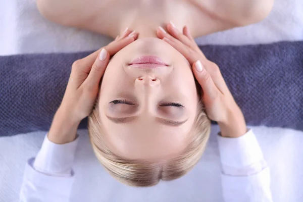 Jonge vrouw liggend op een massagetafel, ontspannend met gesloten ogen. Vrouw. Kuuroord — Stockfoto