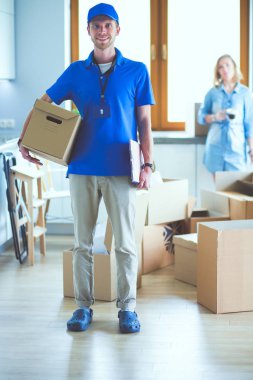 Mavi üniformalı gülümseyen kurye servis konseptine paket kutusu teslim eden teslimatçı. Mavi üniformalı gülümseyen teslimatçı.