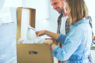 Genç bir çift yeni evde büyük karton kutu taşıyan. Ev taşıma. Genç Çift