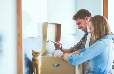 Genç bir çift yeni evde büyük karton kutu taşıyan. Ev taşıma. Genç Çift