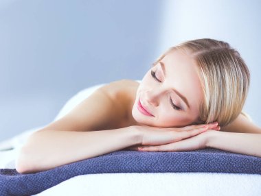 Masaj masasında uzanmış gözleri kapalı rahatlayan genç bir kadın. - Kadın. Spa salonu