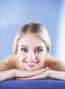 Bir masaj masanın üzerinde yatan, rahatlatıcı bir genç kadın. Kadın. Spa Salonu