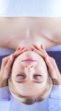 Masaj masasında uzanmış gözleri kapalı rahatlayan genç bir kadın. - Kadın. Spa salonu