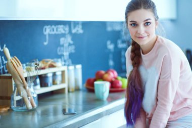 Mutfakta masada oturan genç kadın.