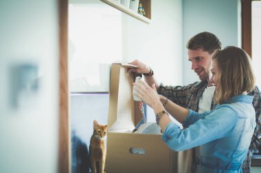 Genç bir çift yeni evde büyük karton kutu taşıyan. Ev taşıma. Genç Çift