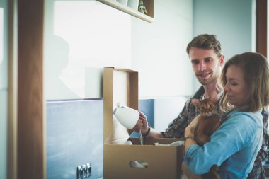 Genç bir çift yeni evde büyük karton kutu taşıyan. Ev taşıma. Genç Çift