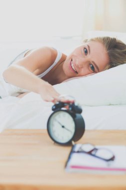Genç kadın ve çalar saat evde yatak odasında uyuyor. Genç uyuyan kadın.