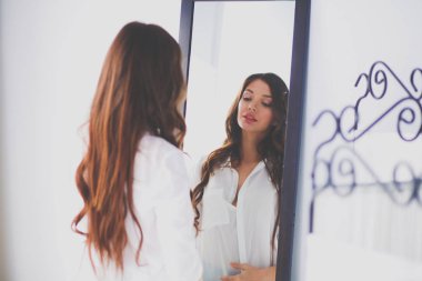 Genç kadın kendini yansıma evde aynaya bakıyorum. Genç kadın.