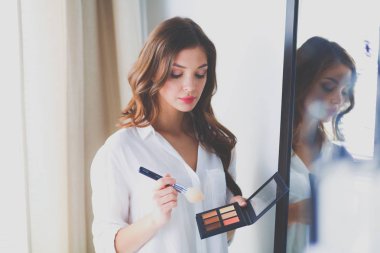 Genç kadın kendini yansıma evde aynaya bakıyorum. Genç kadın.