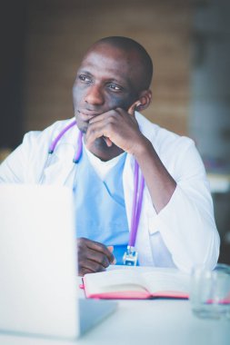 Masada dizüstü bilgisayarla çalışan genç bir Afrikalı doktor. Doktor bey. İşyeri