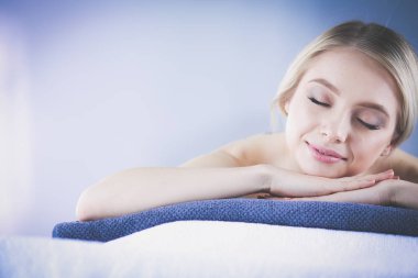 Masaj masasında uzanmış gözleri kapalı rahatlayan genç bir kadın. - Kadın. Spa salonu