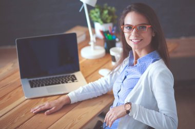 Masada oturan genç bir kadın..