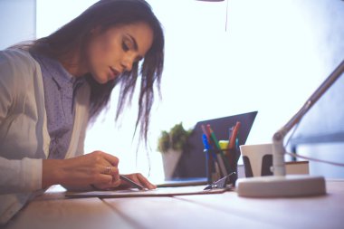 Masada oturan genç bir bayan. İş kadınıyım. Çizim. Öğrenci. İş yeri. Masa.