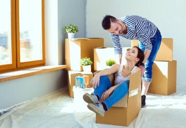 Açma veya kutu ambalaj ve yeni evine taşıdıktan mutlu genç bir çift. Genç Çift