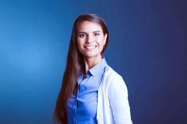 Esmer arka planda bir iş kadınının portresi. Gülümseyen kadın. Bir kadın portresi