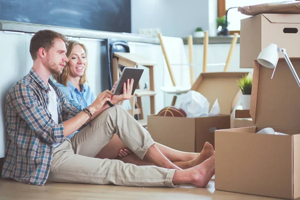 Genç bir çift yeni ev içinde hareket. Oturma ve açma sonra rahatlatıcı. Bir şey üstünde laptop arıyorum. Genç Çift