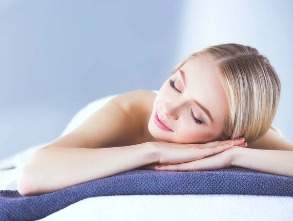 Masaj masasında uzanmış gözleri kapalı rahatlayan genç bir kadın. - Kadın. Spa salonu