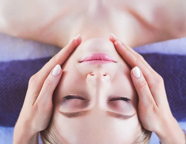 Ung kvinna liggande på ett massagebord, avslappnande med slutna ögon. Kvinnan. Spasalong — Stockfoto