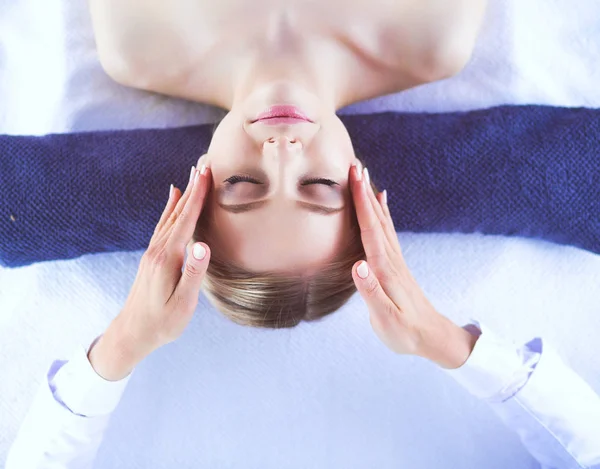 Mujer joven acostada en una mesa de masaje, relajándose con los ojos cerrados. Una mujer. Salón de spa — Foto de Stock