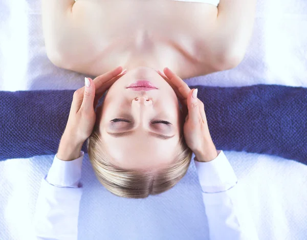 Jonge vrouw liggend op een massagetafel, ontspannend met gesloten ogen. Vrouw. Kuuroord — Stockfoto