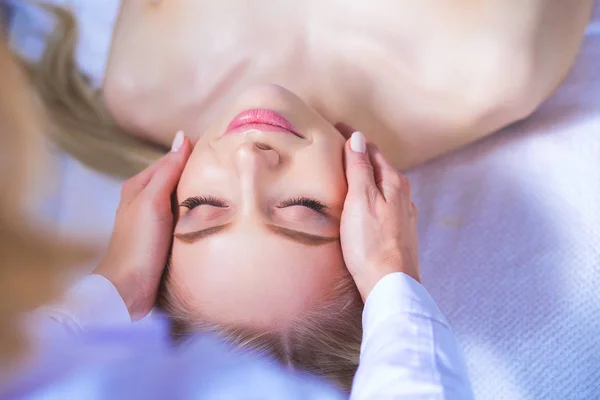 Jeune femme allongée sur une table de massage, relaxante les yeux fermés. Femme. Salon de spa — Photo