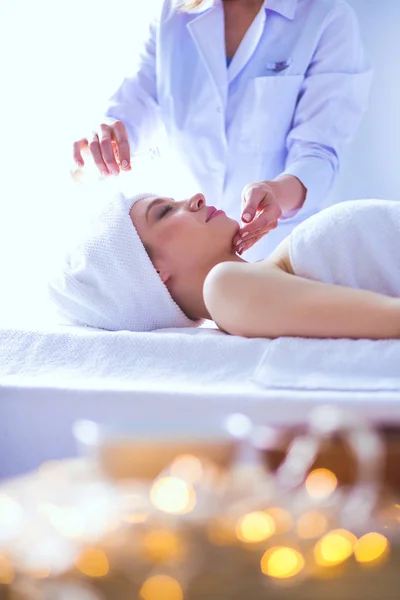 Jovem deitada em uma mesa de massagem, relaxando com os olhos fechados. Mulher. Salão de Spa — Fotografia de Stock