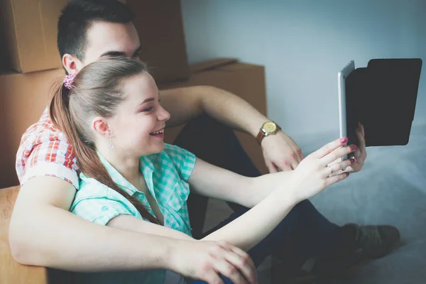 Coppia che si trasferisce in casa seduta sul pavimento con ipad. Coppia — Foto Stock