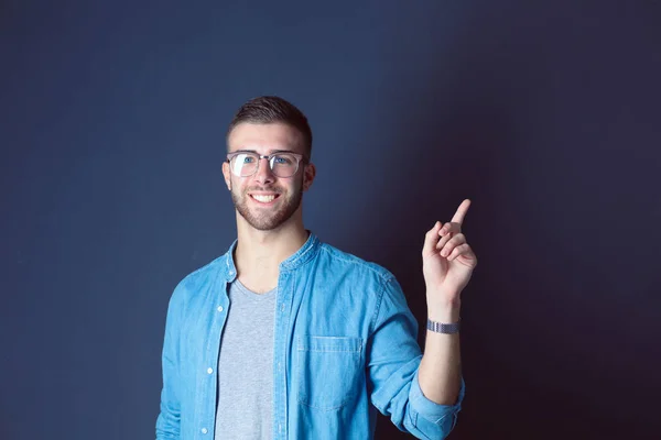 Porträt eines lächelnden jungen Mannes, der nach oben zeigt. — Stockfoto